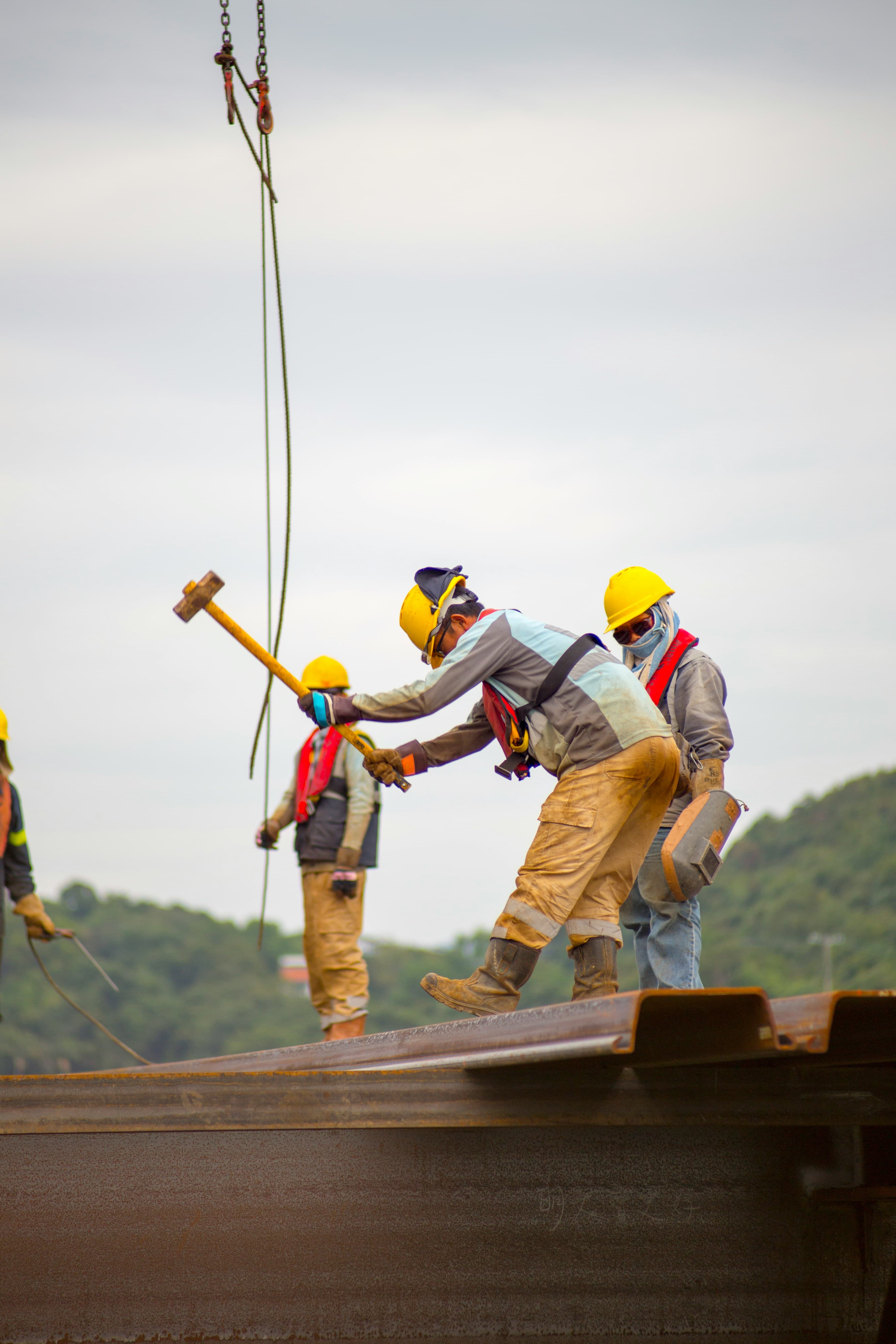 A construction crew in hard hats working on a steel structure